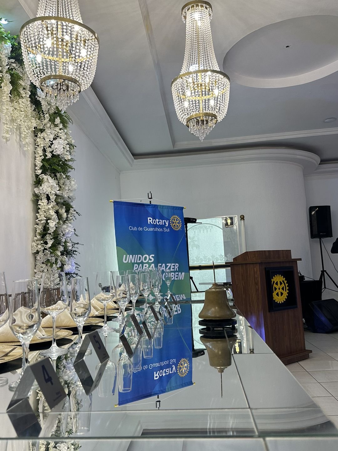 Mesa montada e púlpito preparado para as falas do evento corporativo