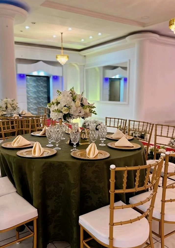 Mesa posta com cadeiras douradas no salão do Estrela Buffet